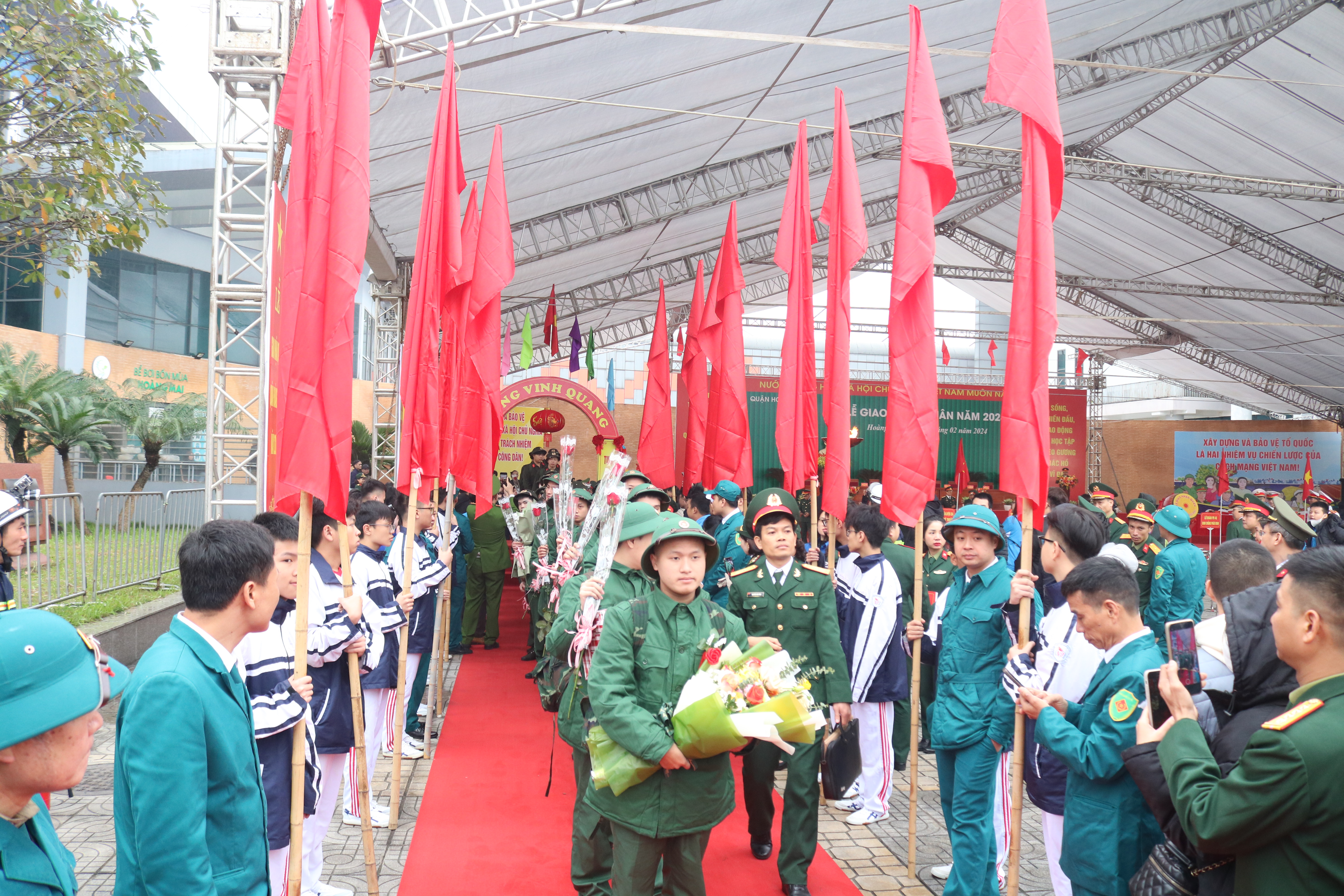 A group of people in uniform holding flagsDescription automatically generated